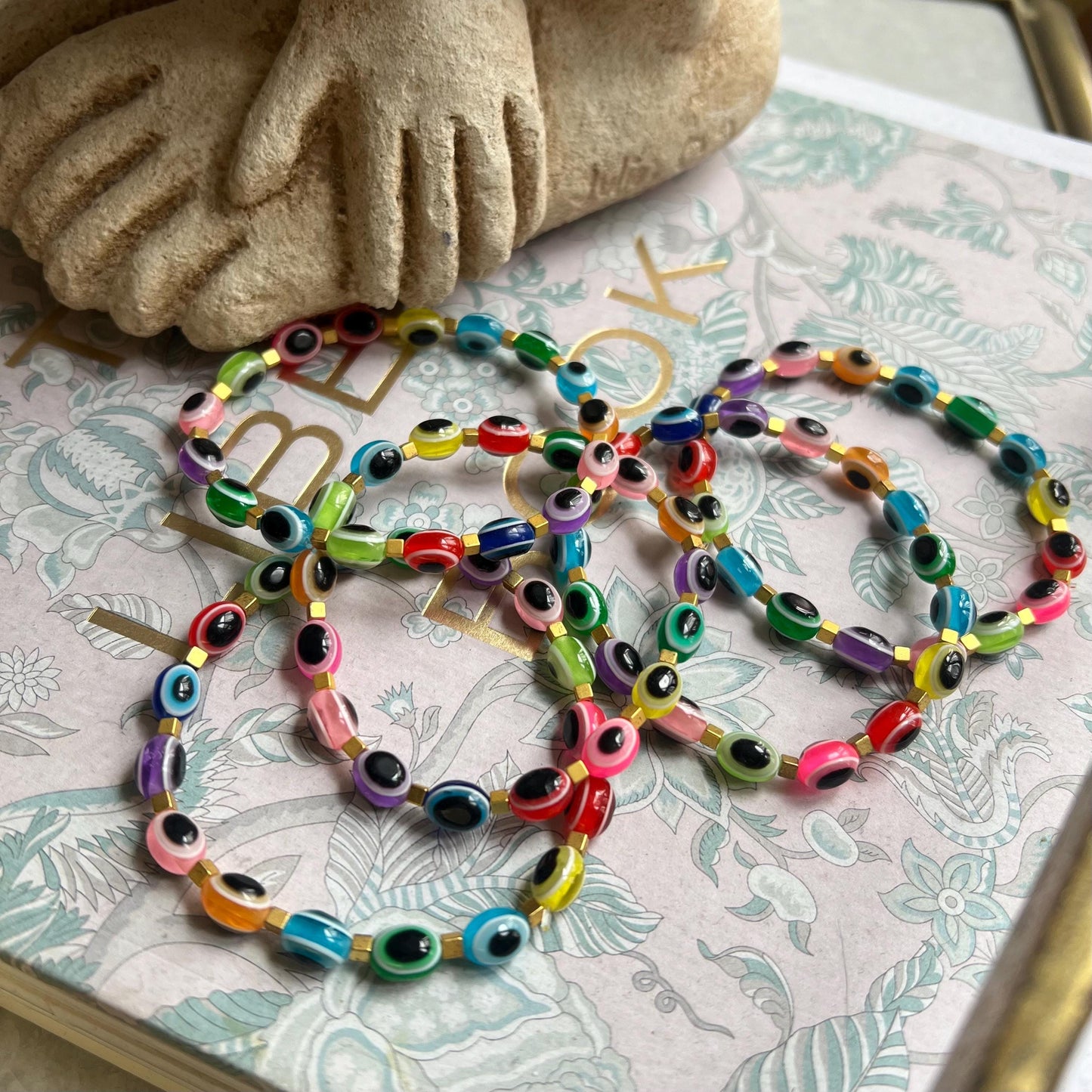 Tutti frutti evil eye bracelet styled with other jewelry - colorful spiritual accessory stack