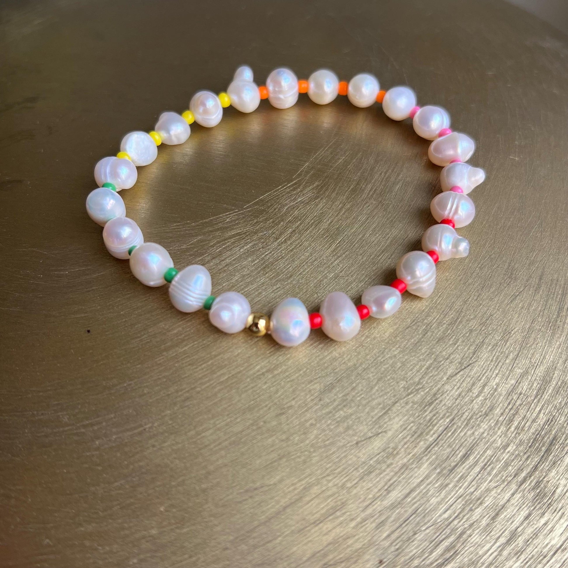 Close-up of genuine freshwater pearls and vibrant rainbow seed beads with 14k gold accent detail