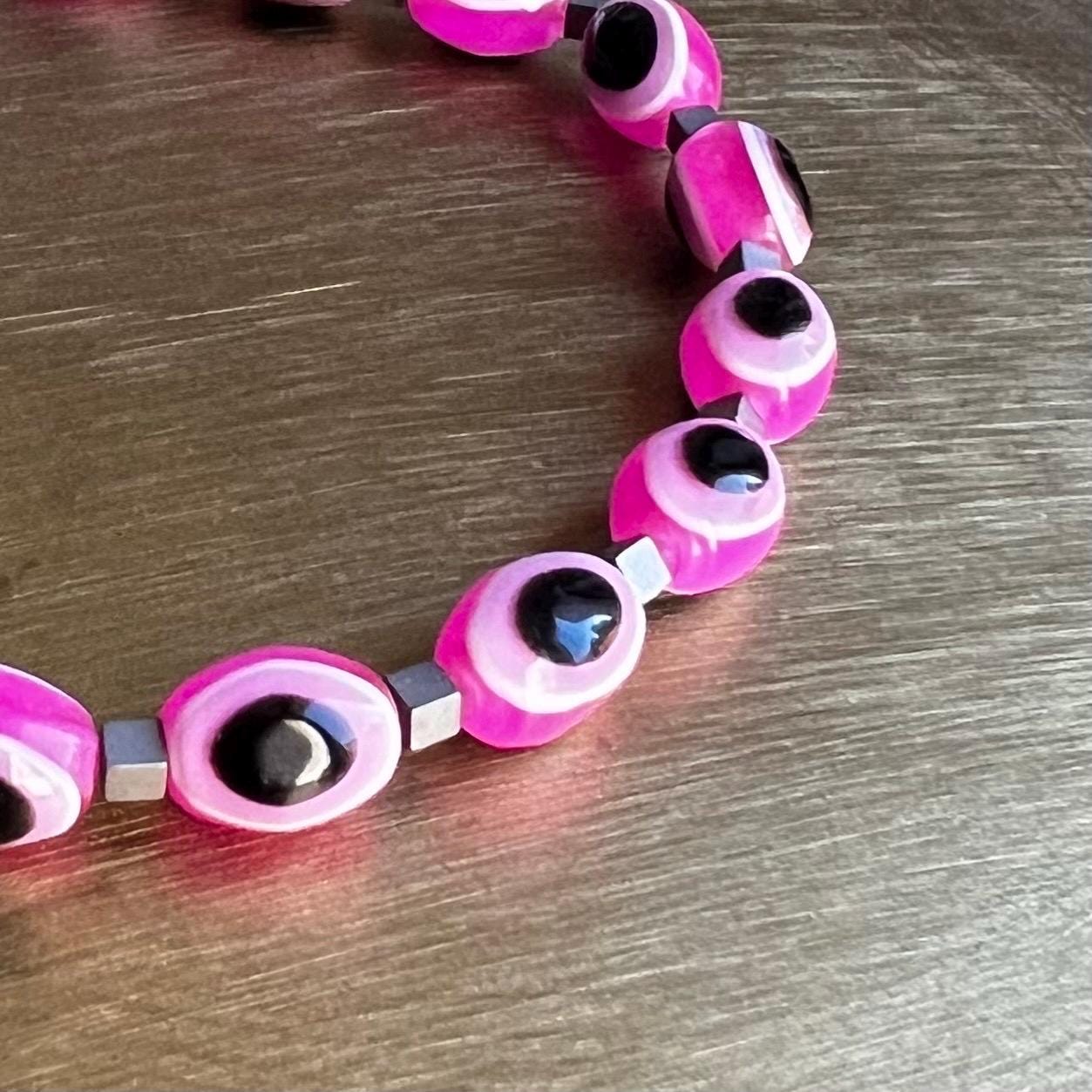 Close-up of pink evil eye beads on stretchy protection bracelet