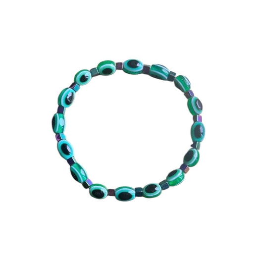 Emerald green evil eye bracelet flat lay - elegant spiritual protection accessory